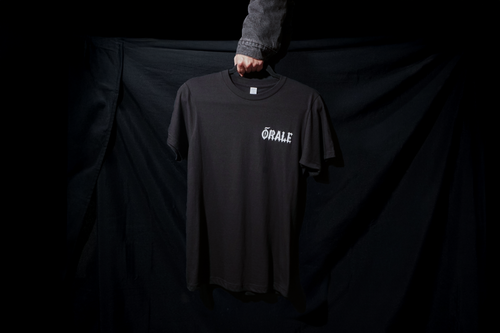 Black t-shirt with 'ORALE' logo held by a person against a black background